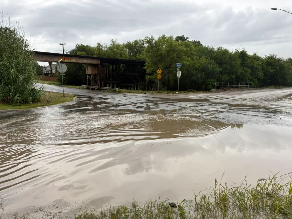 Flooding at the Judson Road and Lookout Road intersection under a railroad bridge, showing drainage improvement needs.