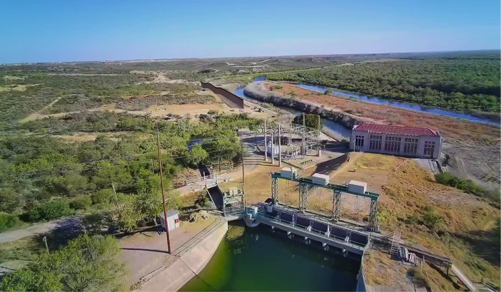 Aerial view of a dam and water intake structure on a Texas river