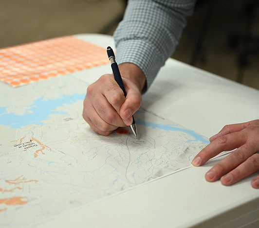 Engineer marking up a floodplain map by hand