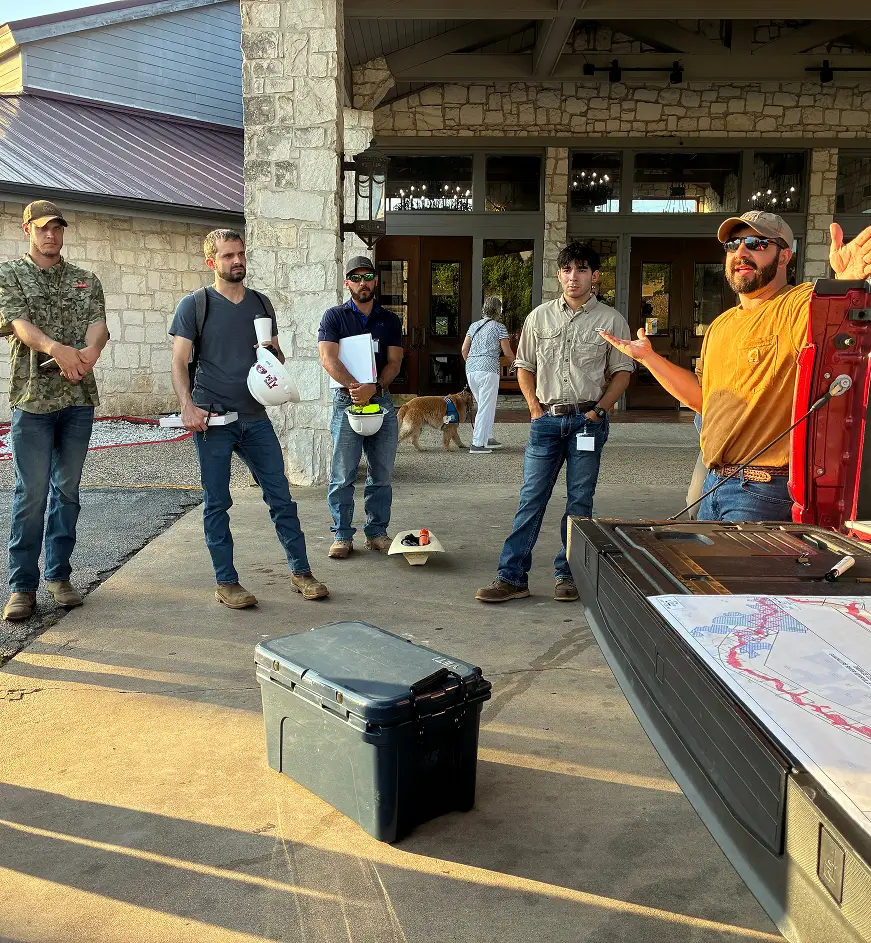 Streamline Engineering team gathered for a field briefing around a floodplain map